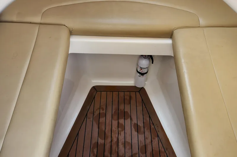 Slide: The Image of 2008 Boston Whaler 320 Outrage Cuddy Cabin interior with cushioned seating and wooden flooring. - 23
