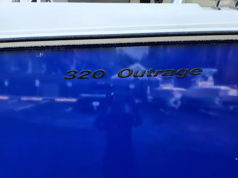 Slide: The Image of 2008 Boston Whaler 320 Outrage Cuddy Cabin, blue hull with model name displayed. - 37