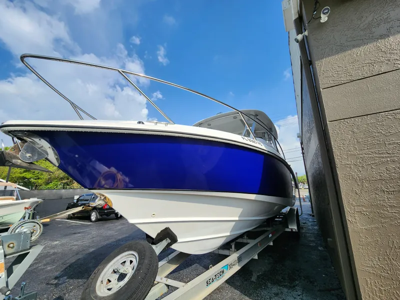 Slide: The Image of 2008 Boston Whaler 320 Outrage Cuddy Cabin on trailer, blue hull, parked outdoors. - 39