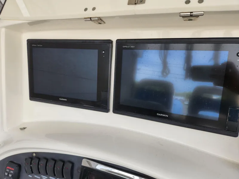 Slide: The Image of 2008 Boston Whaler 320 Outrage Cuddy Cabin dashboard with Garmin displays. - 8