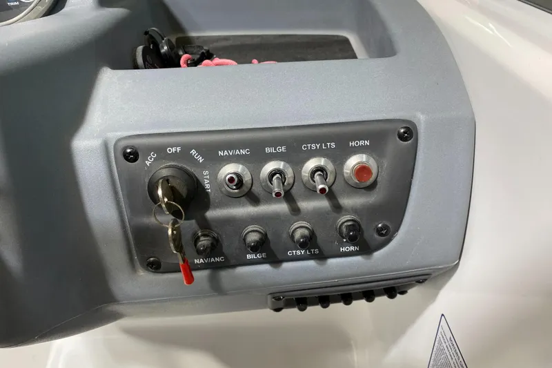 Slide: The Image of Control panel of a 2021 Tahoe T18 boat with switches and ignition key. - 13