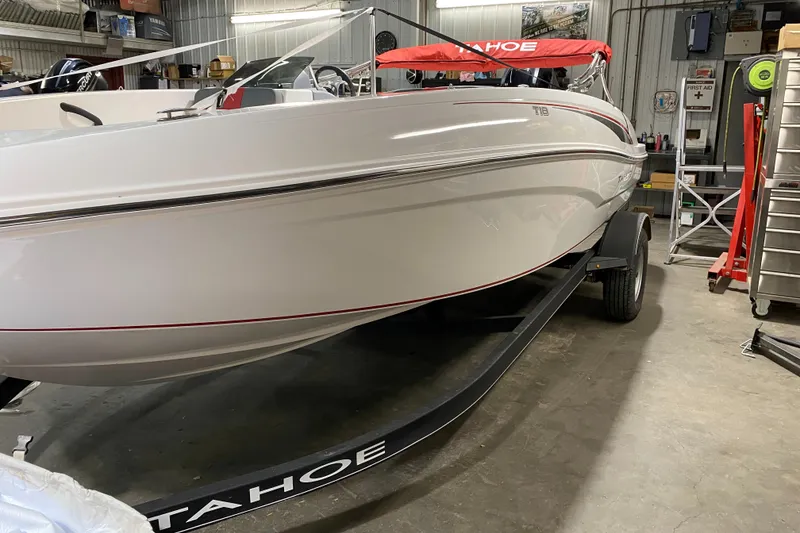 Slide: The Image of 2021 Tahoe T18 boat in a garage, on a trailer, with red canopy. - 3