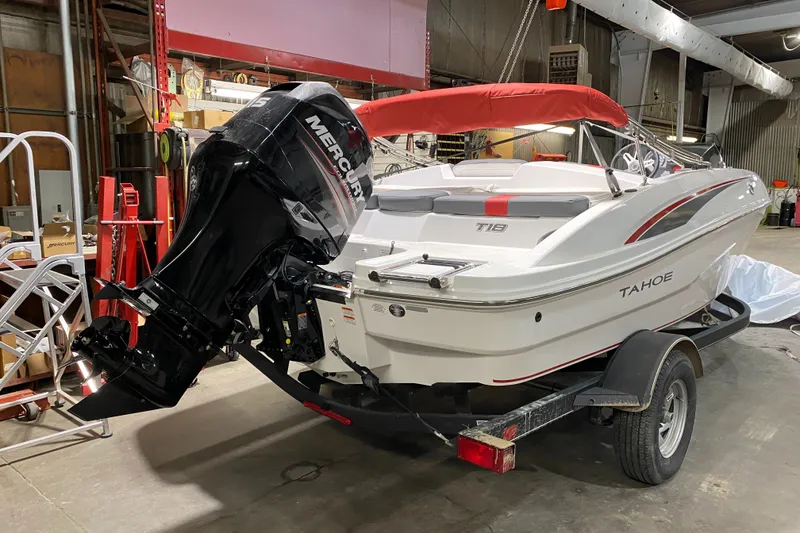 Slide: The Image of 2021 Tahoe T18 boat with red canopy and Mercury outboard motor in a workshop. - 4
