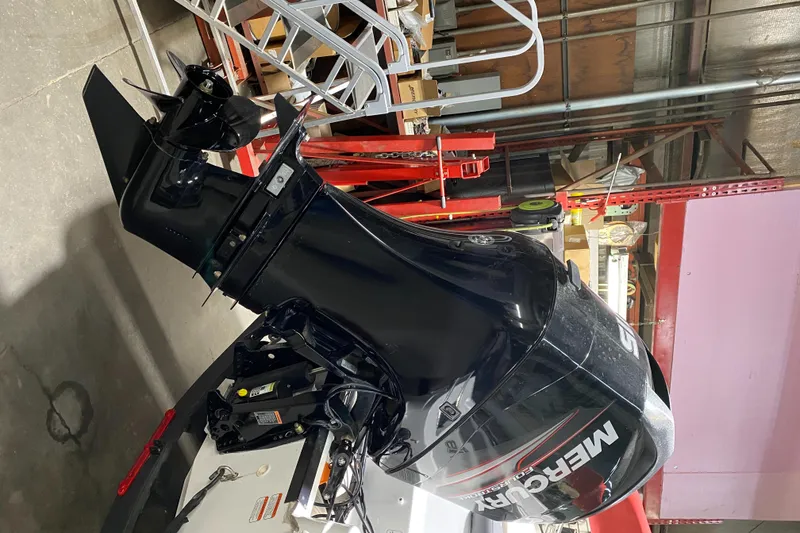 Slide: The Image of 2021 Tahoe T18 boat with Mercury outboard motor in a workshop setting. - 6