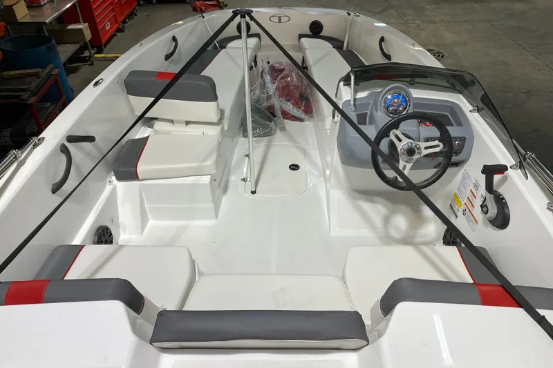 Slide: The Image of 2021 Tahoe T18 boat interior with seating and steering wheel in a garage setting. - 7