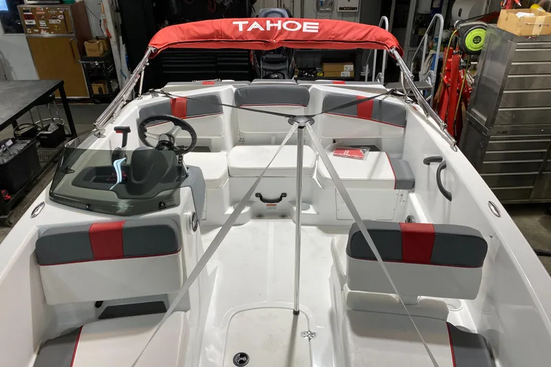 Slide: The Image of 2021 Tahoe T18 boat interior with red and gray seating, steering wheel, and canopy. - 8
