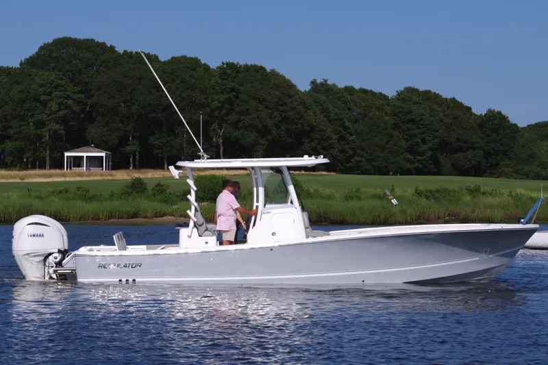 Slide: The Image of 2024 Regulator 30XO boat on calm water with lush green background. - 10