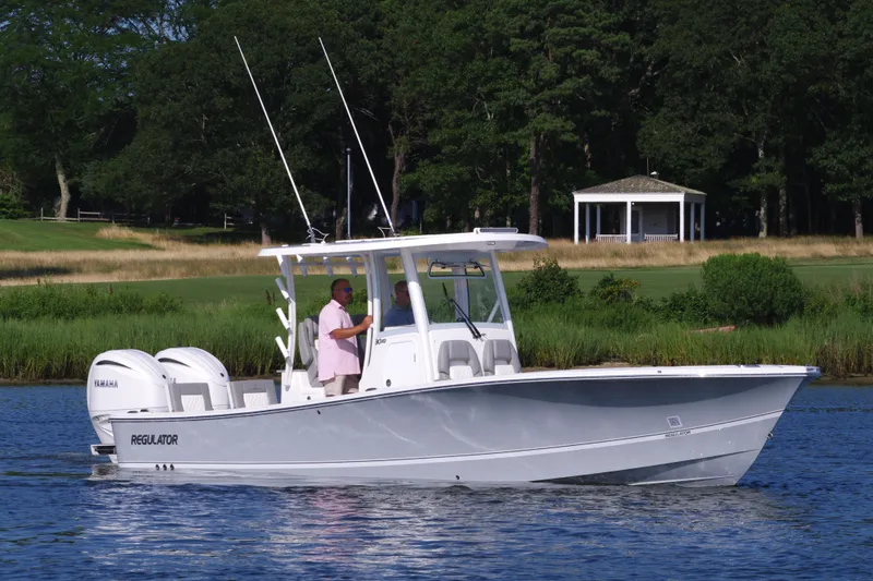 Slide: The Image of 2024 Regulator 30XO boat on a calm lake with a gazebo in the background. - 11