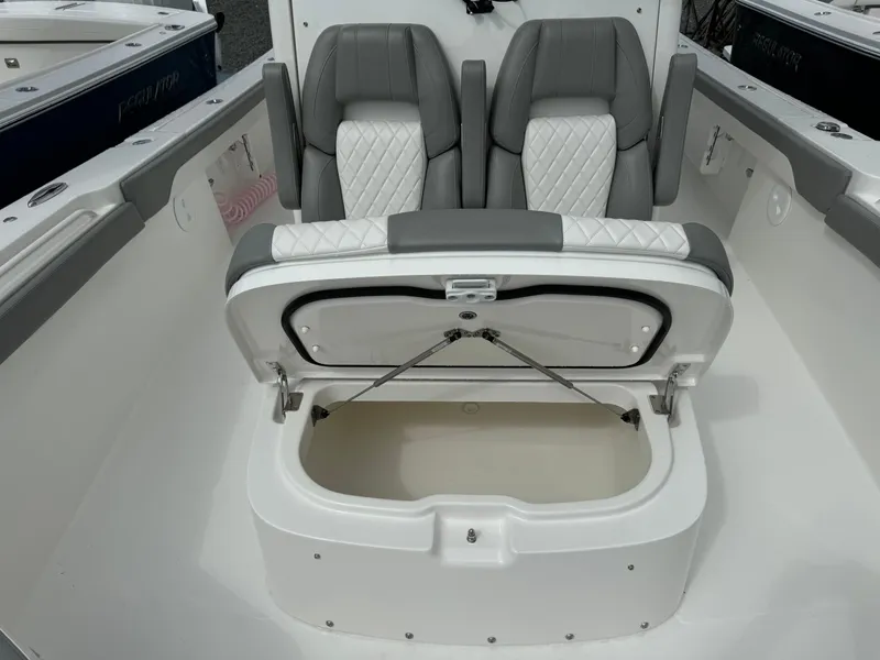 Slide: The Image of 2024 Regulator 30XO boat with open storage compartment and dual seats. - 24