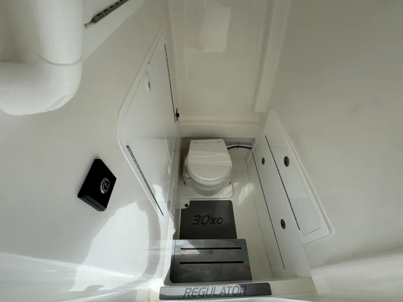 Slide: The Image of 2024 Regulator 30XO boat interior with toilet and storage compartments. - 26