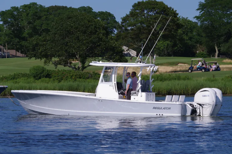 Slide: The Image of 2024 Regulator 30XO boat on calm water with lush green background. - 4