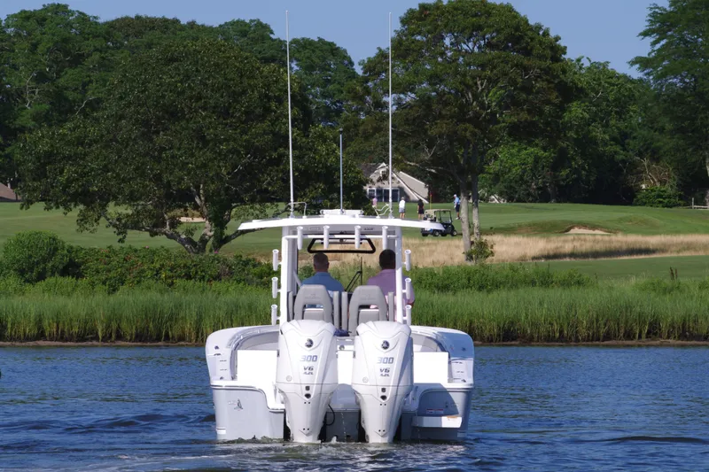 Slide: The Image of 2024 Regulator 30XO boat cruising on a lake with lush greenery in the background. - 7