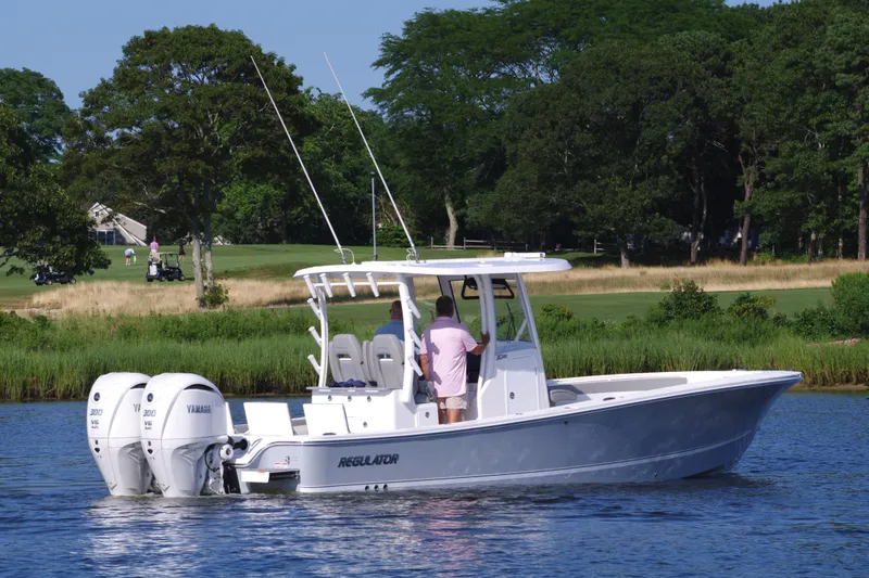Slide: The Image of 2024 Regulator 30XO boat with twin Yamaha engines on a calm lake. - 9