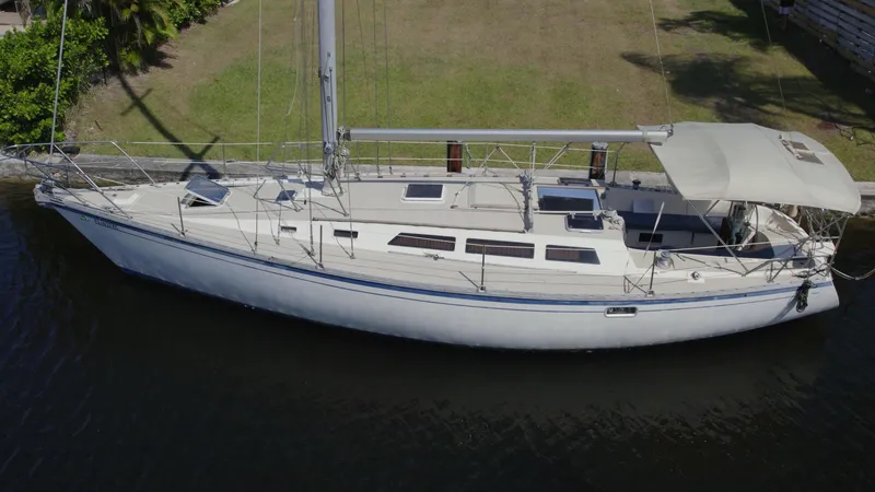 Slide: The Image of 1986 O'Day 39 sailboat with aft cockpit, docked on calm water. - 1