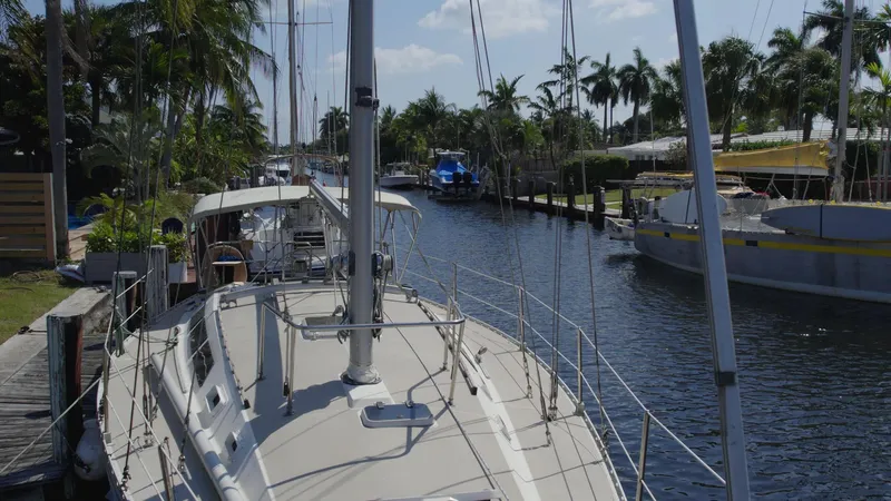 Slide: The Image of 1986 O'Day 39 sailboat docked in a sunny canal with palm trees. - 10