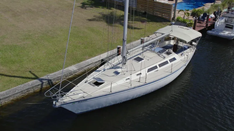 Slide: The Image of 1986 O'Day 39 Aft Cockpit sailboat docked by grassy shore. - 17