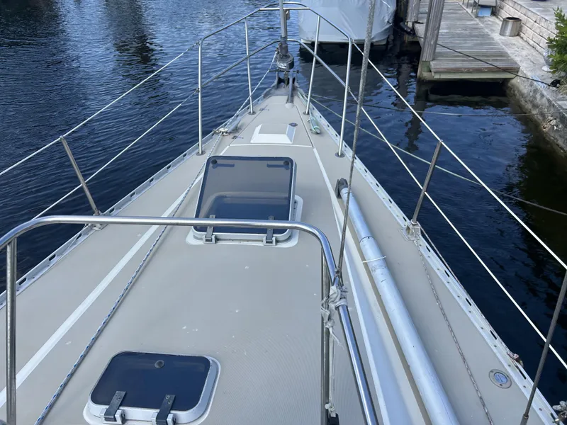 Slide: The Image of 1986 O'Day 39 sailboat deck with aft cockpit, docked by the water. - 22