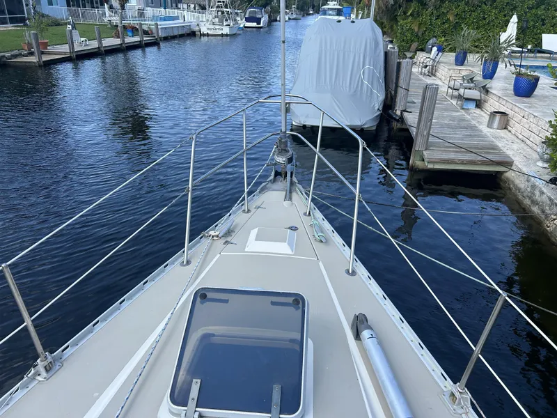 Slide: The Image of 1986 O'Day 39 sailboat docked in a serene marina setting. - 24