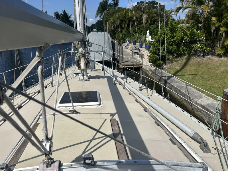 Slide: The Image of 1986 O'Day 39 sailboat deck, aft cockpit, docked by lush greenery. - 29