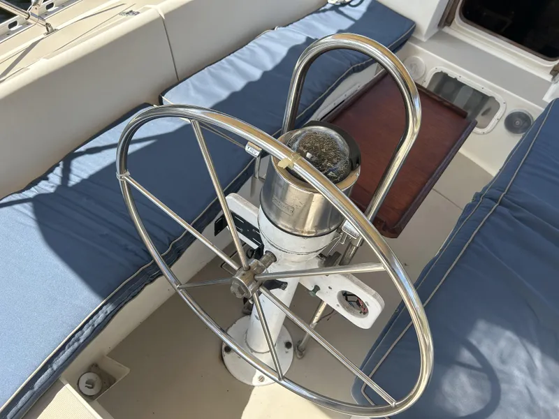 Slide: The Image of 1986 O'Day 39 Aft Cockpit sailboat helm with blue cushions and wooden table. - 32