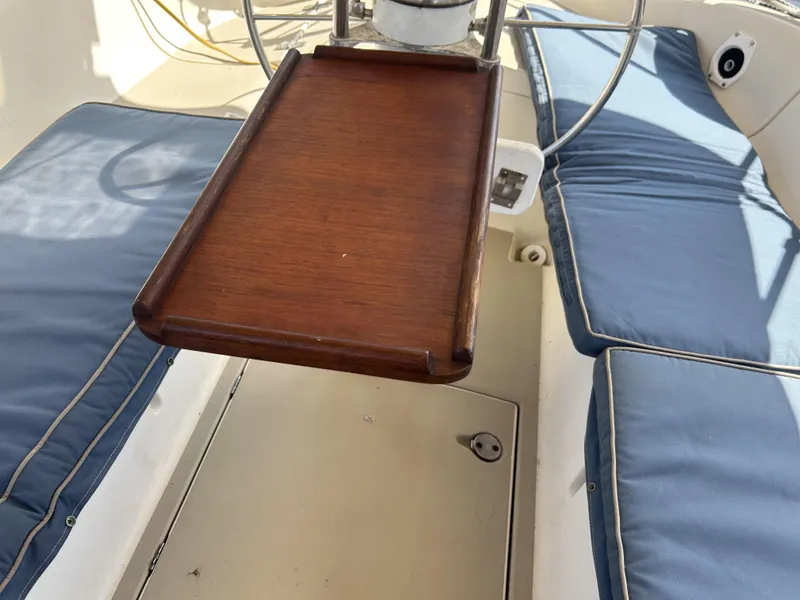 Slide: The Image of 1986 O'Day 39 Aft Cockpit with wooden table and blue cushioned seating. - 34