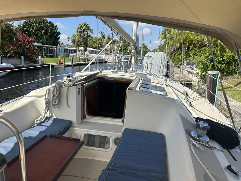 Slide: The Image of 1986 O'Day 39 sailboat with aft cockpit, docked in a sunny canal setting. - 44