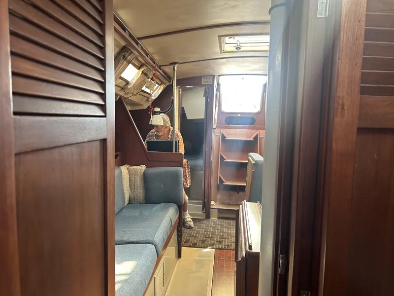 Slide: The Image of Interior of 1986 O'Day 39 sailboat, featuring cozy seating and wooden cabinetry. - 45