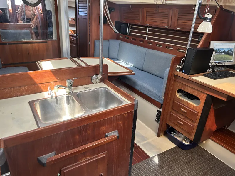 Slide: The Image of Interior of 1986 O'Day 39 sailboat with wood finish, kitchenette, and seating area. - 48