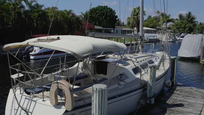Slide: The Image of 1986 O'Day 39 sailboat docked in a sunny marina, featuring an aft cockpit design. - 6