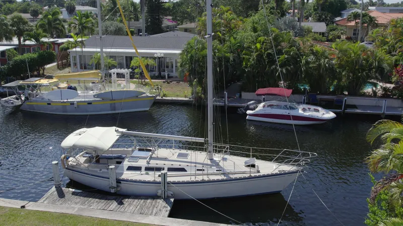 Slide: The Image of 1986 O'Day 39 sailboat docked in a scenic canal with lush greenery. - 9