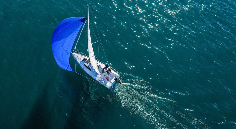 Slide: The Image of 2025 Beneteau First 24 sailboat with blue spinnaker on open water. - 7