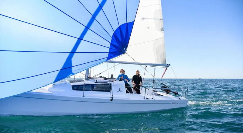 Slide: The Image of 2025 Beneteau First 24 sailboat navigating on open water under clear blue skies. - 8