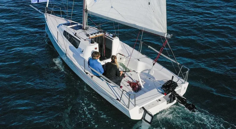 Slide: The Image of 2025 Beneteau First 24 sailboat on open water with two people onboard. - 9