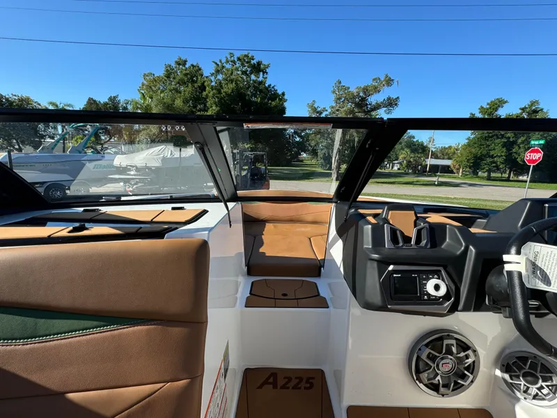 Slide: The Image of 2023 Axis A225 boat interior with brown seats and modern dashboard. - 13