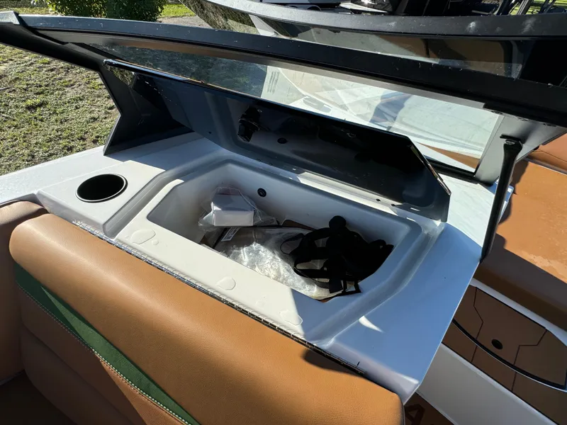 Slide: The Image of 2023 Axis A225 boat storage compartment with open lid and brown seating. - 16
