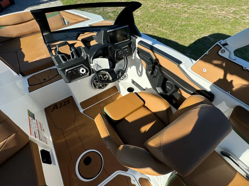 Slide: The Image of 2023 Axis A225 boat interior with brown leather seats and modern dashboard. - 17