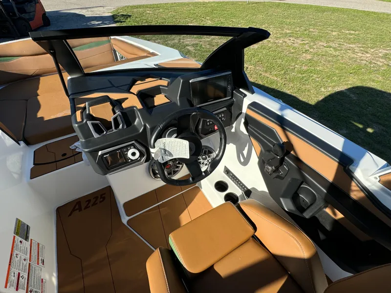 Slide: The Image of 2023 Axis A225 boat interior with tan seats and modern dashboard. - 19