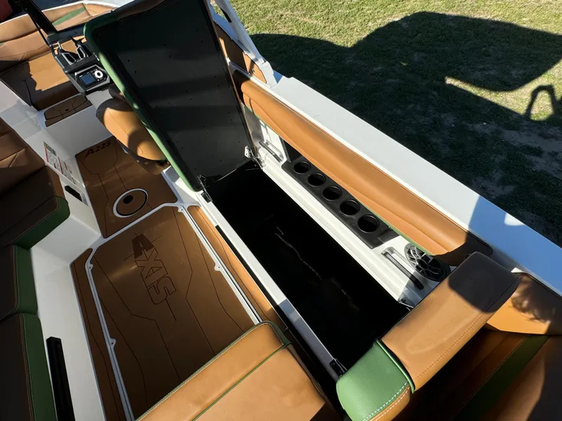 Slide: The Image of 2023 Axis A225 boat interior with open storage compartment and brown seating. - 23