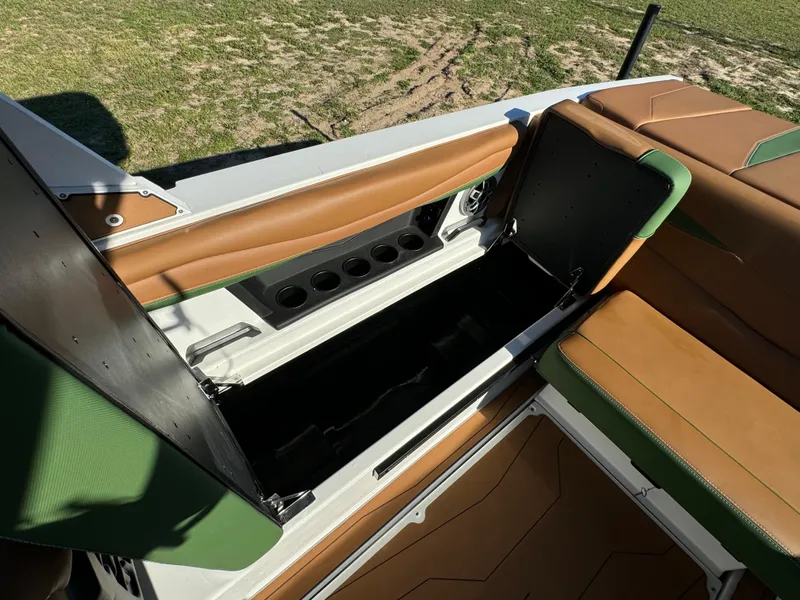 Slide: The Image of 2023 Axis A225 boat with open storage compartment and cup holders. - 24