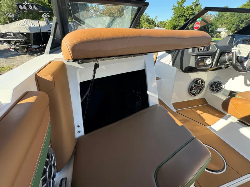 Slide: The Image of 2023 Axis A225 boat interior with brown leather seats and modern dashboard. - 26