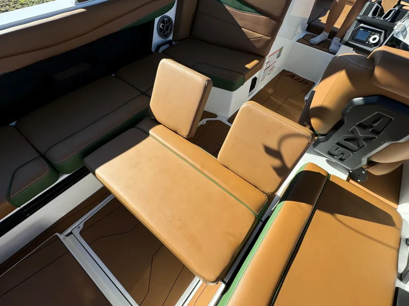 Slide: The Image of 2023 Axis A225 boat interior with brown leather seating and green accents. - 31