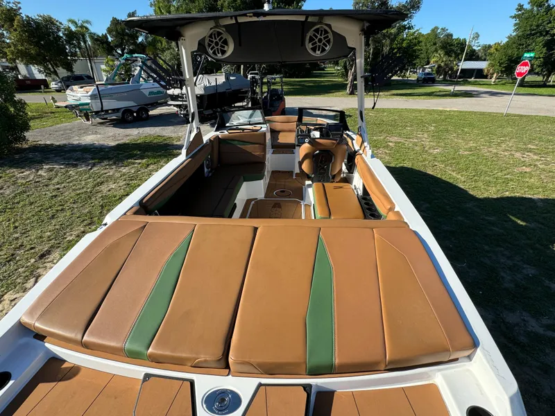Slide: The Image of 2023 Axis A225 boat with brown and green interior, parked on grass. - 33