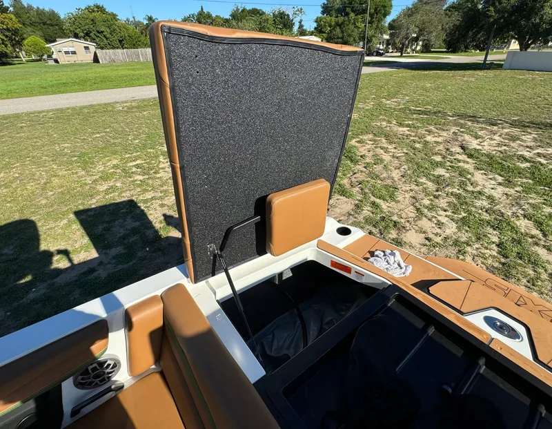 Slide: The Image of 2023 Axis A225 boat interior with open storage compartment and brown seating. - 36