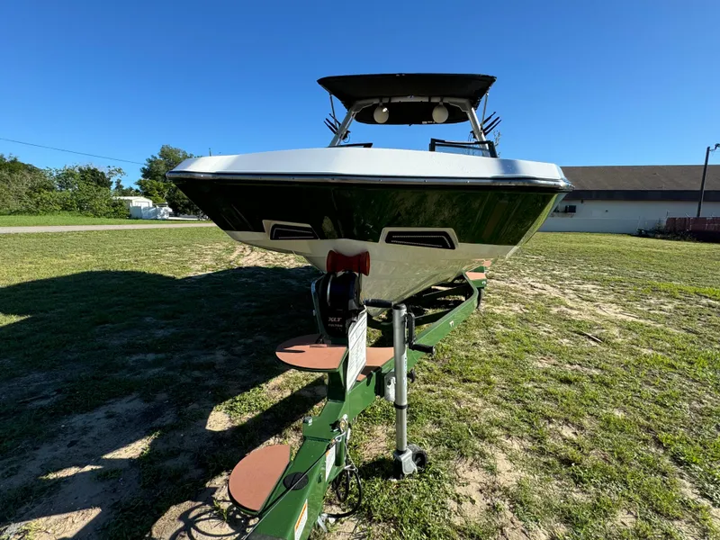 Slide: The Image of 2023 Axis A225 boat on a green trailer in a grassy area. - 4