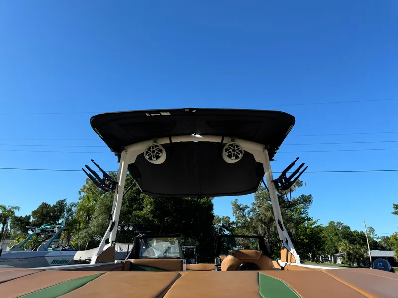 Slide: The Image of 2023 Axis A225 boat with wakeboard tower and speakers against a clear blue sky. - 43