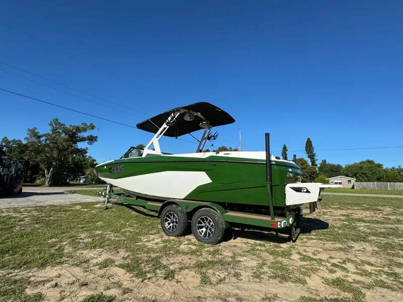 Slide: The Image of 2023 Axis A225 boat on trailer, green and white, parked outdoors. - 5