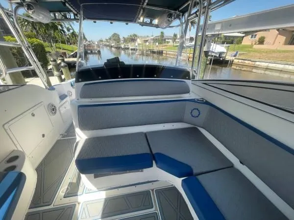 Slide: The Image of 2005 Fountain 38 LX boat interior with gray and blue seating, docked by a canal. - 10