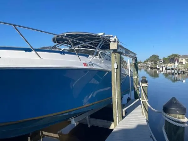 Slide: The Image of 2005 Fountain 38 LX boat docked by a serene waterfront. - 3