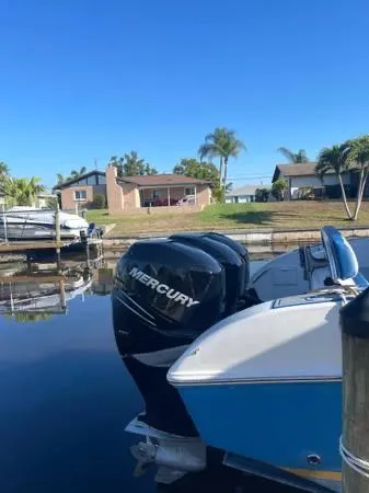 Slide: The Image of 2005 Fountain 38 LX boat with Mercury engines docked by waterfront homes. - 8
