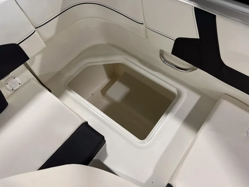 Slide: The Image of 2023 Bayliner VR5 Bowrider interior storage compartment with white and black seating. - 4